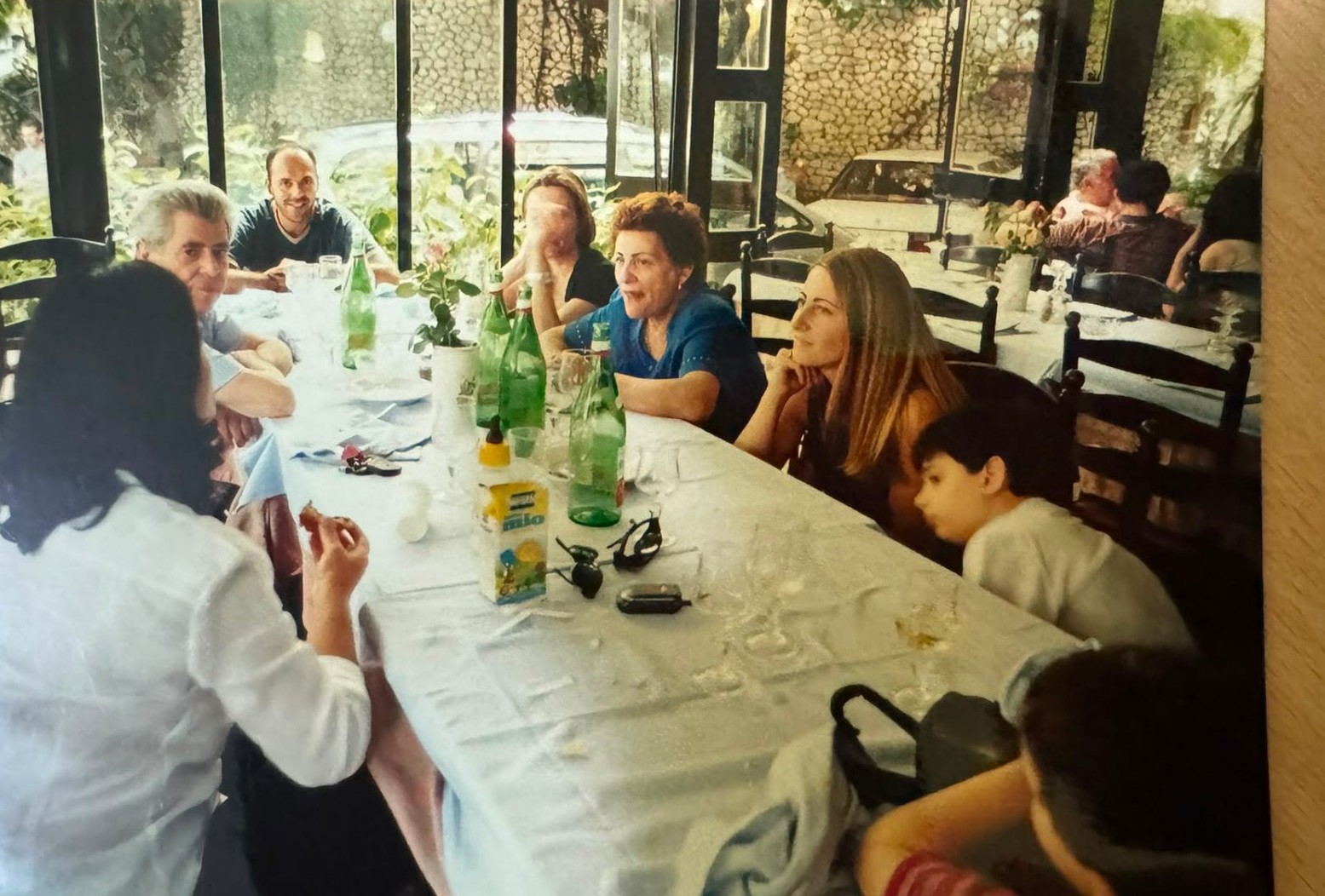 Family long lunch around a restaurant table in Italy
